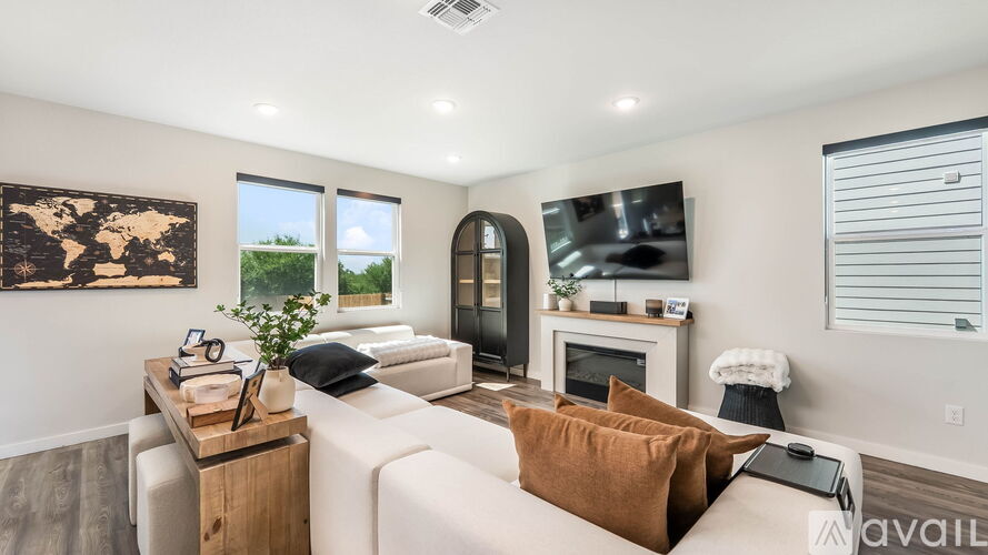 A living room with a white couch, a wooden coffee table, and a large window.