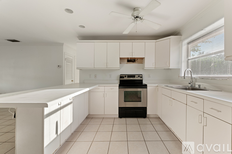 A kitchen with white cabinets and appliances.
