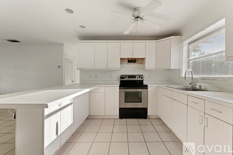 A kitchen with white cabinets and appliances.