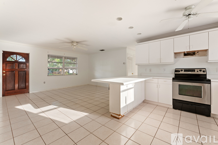 A kitchen with white cabinets and a black oven.