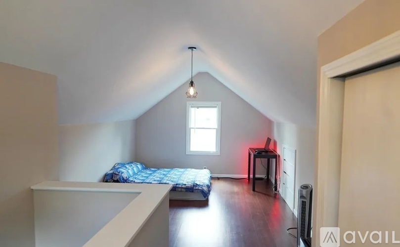 A bedroom with a bed, a chair, and a window.