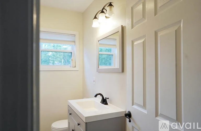 A bathroom with a white sink and a window.
