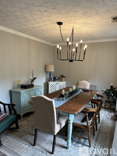 A dining room with a wooden table and chairs.