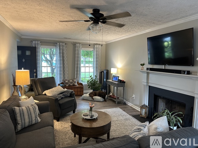 A living room with a fireplace and a television on the wall.