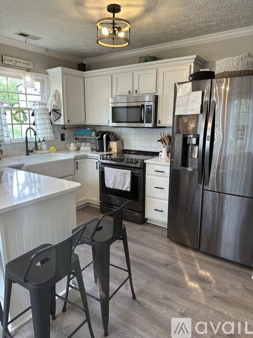 A kitchen with a white counter top and a black stove.