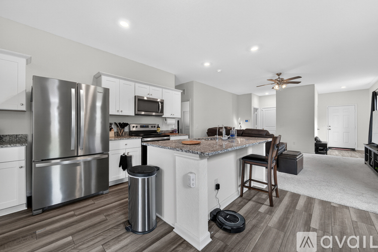 A modern kitchen with a stainless steel refrigerator and a wooden island.