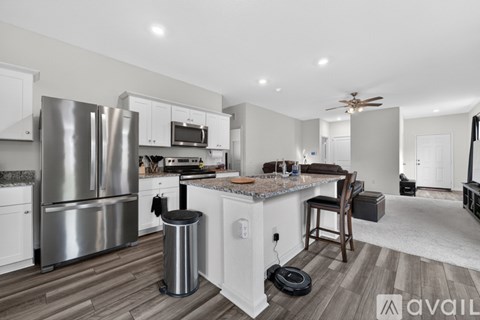 A modern kitchen with a stainless steel refrigerator and a wooden island.