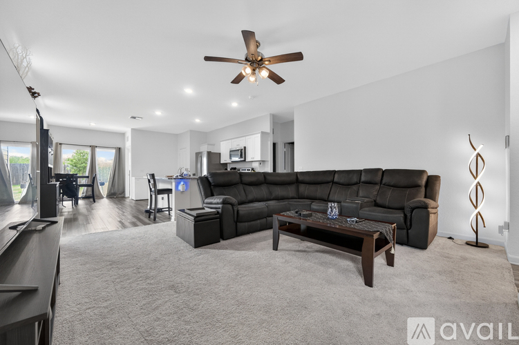 A living room with a large couch and a ceiling fan.