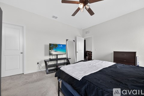 A bedroom with a bed, dresser, and a ceiling fan.