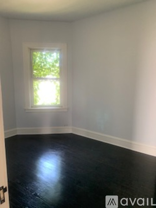 A room with a window and a wooden floor.