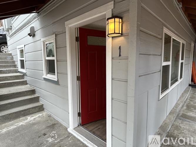 A small house with a red door and a lantern on the wall.