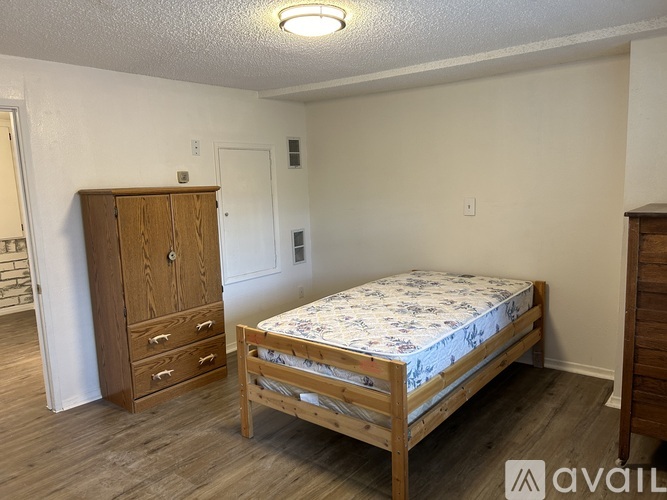 A bedroom with a bed, dresser, and wardrobe.