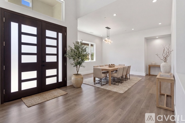 A modern dining room with a wooden floor and a large table with chairs.