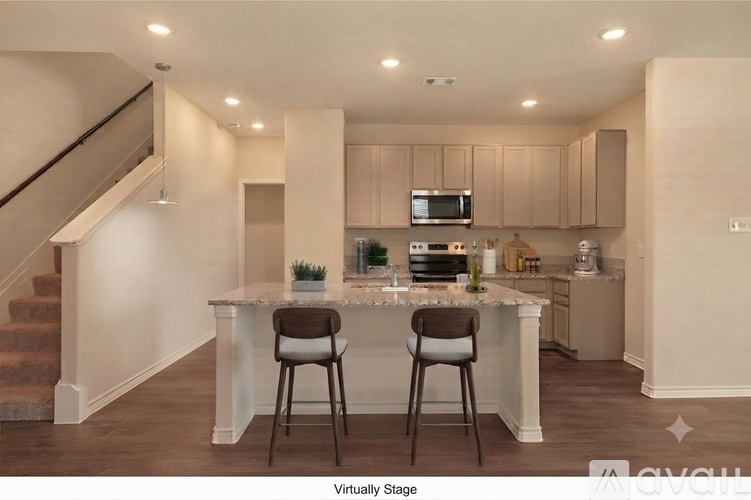 A kitchen with a bar stool in front of a counter.