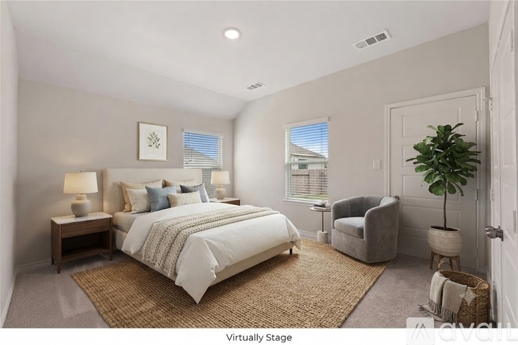 A bedroom with a large bed and a chair.