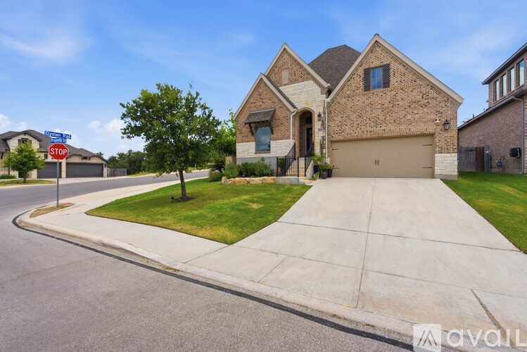 A house with a driveway and a stop sign on the street.
