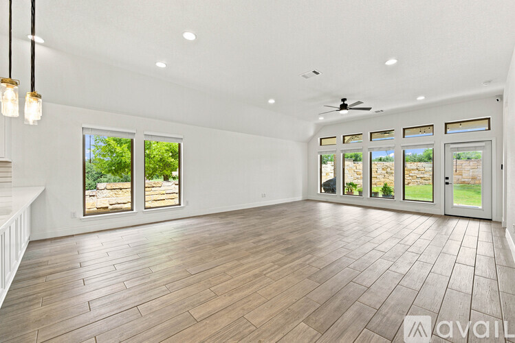 A spacious room with wooden flooring and a ceiling fan.