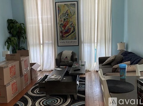 A living room with a large painting by Vasily Kandinsky hanging on the wall.