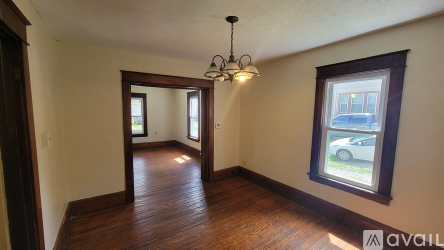 A room with wooden floors and a chandelier hanging from the ceiling.