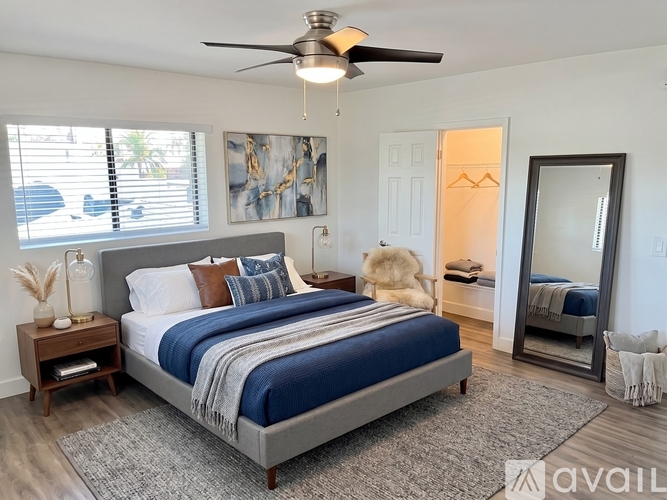 A bedroom with a large bed and a ceiling fan.