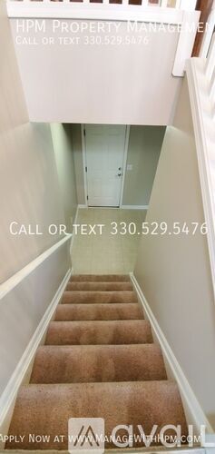A staircase with a carpeted runner and white walls.