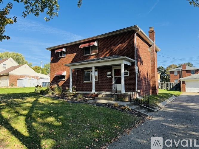 A red brick house with a white door and windows.