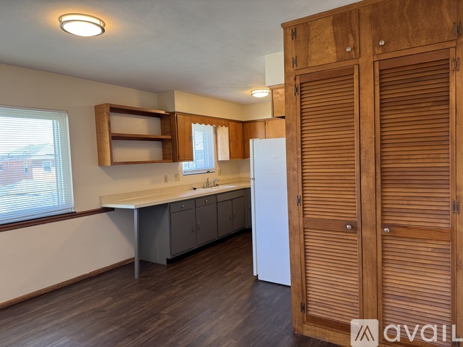 A kitchen with wooden cabinets and a white refrigerator.