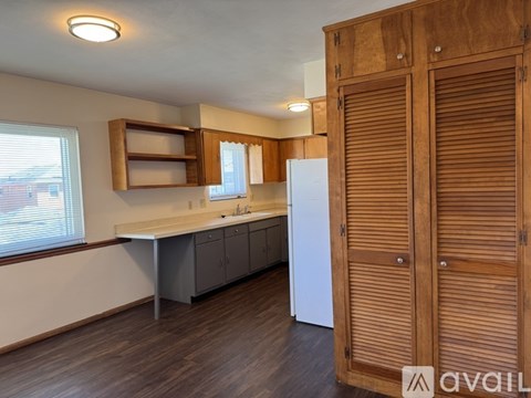 A kitchen with wooden cabinets and a white refrigerator.