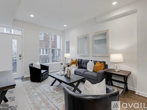 A living room with a grey couch and a black chair.