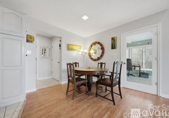 A dining room with a wooden table and chairs.