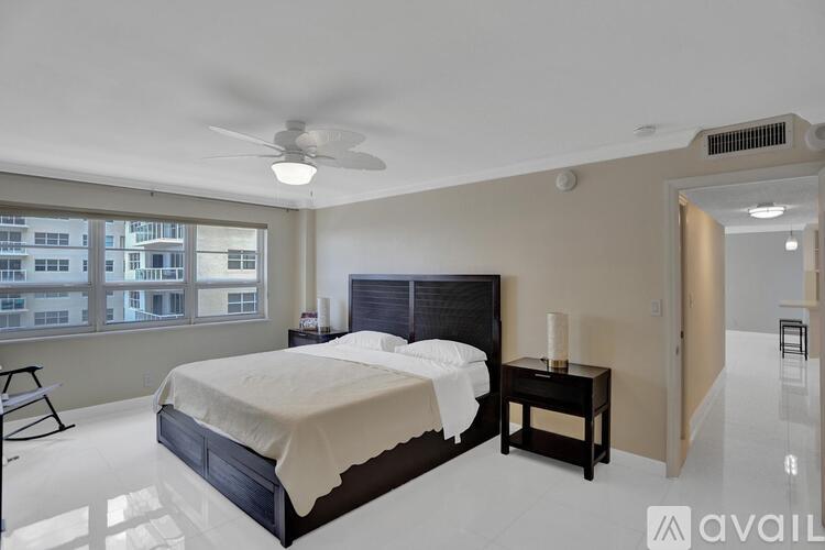 A bedroom with a large bed and a ceiling fan.