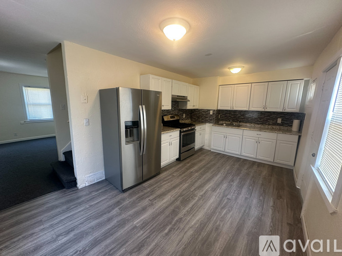 A kitchen with a refrigerator, oven, and cabinets.