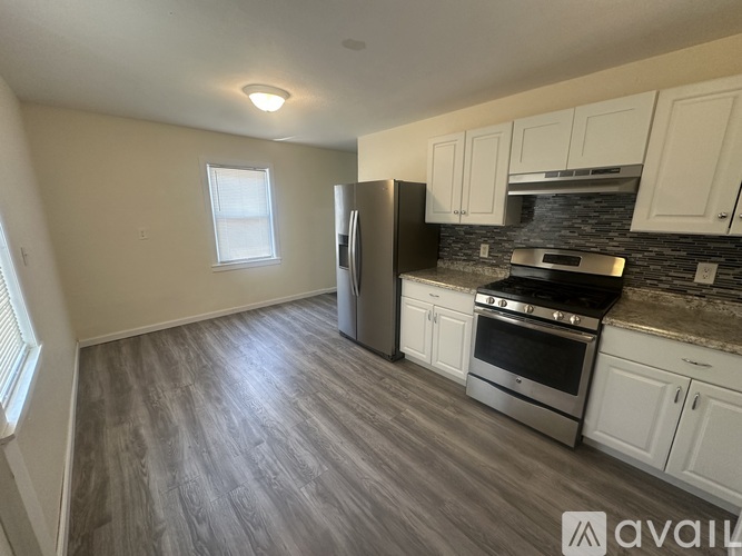 A kitchen with a refrigerator, oven, and cabinets.