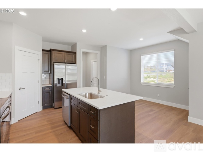 A modern kitchen with dark wood cabinets and a white countertop.