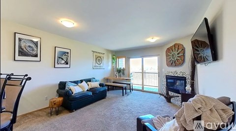 A living room with a blue couch and a fireplace.