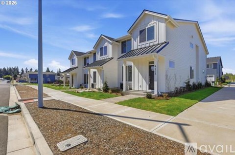 A modern two-story house with a white exterior and a black roof is for sale.