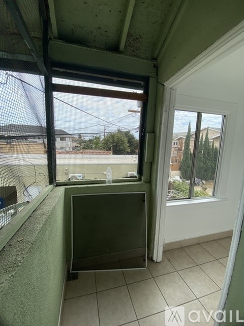 A room with a window overlooking a tennis court.