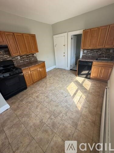 A kitchen with wooden cabinets and a black stove top oven.