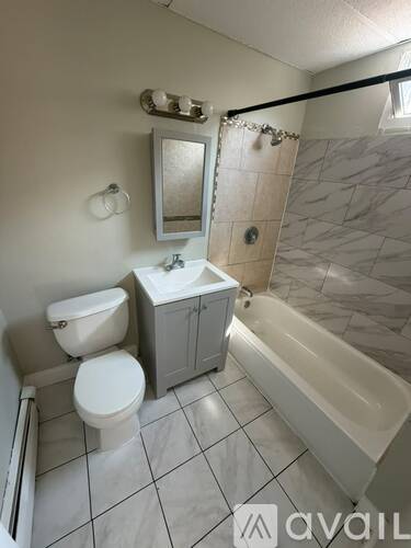 A bathroom with a toilet, sink, and bathtub.