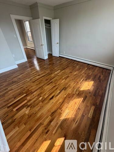 A room with wooden flooring and white walls.