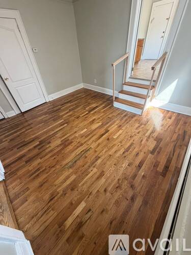 A wooden floor in a room with a staircase.