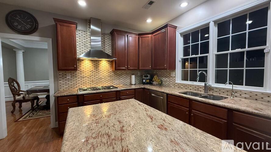 A kitchen with wooden cabinets and a marble countertop.