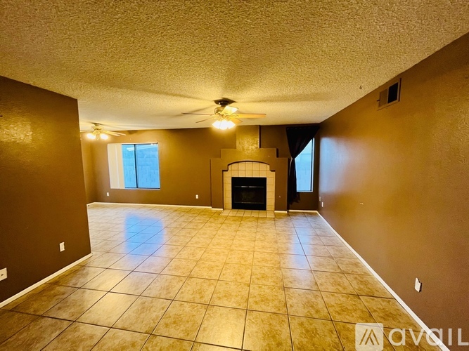 A living room with a fireplace and a ceiling fan.