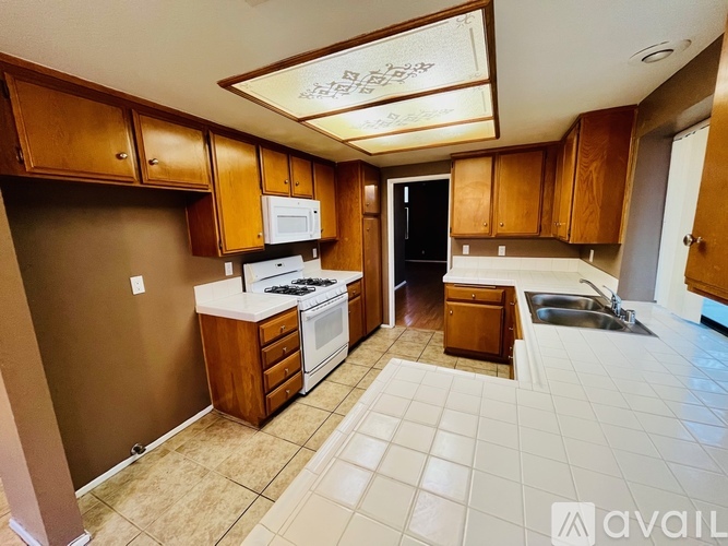 A kitchen with brown cabinets and a white counter top.
