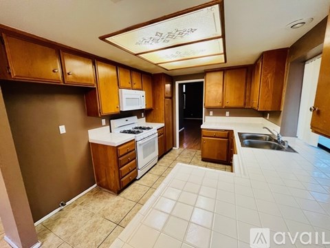 A kitchen with brown cabinets and a white counter top.