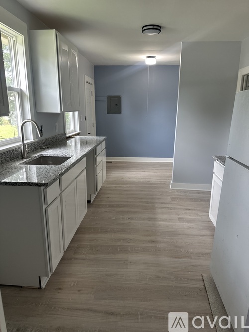 A kitchen with white cabinets and a granite countertop.