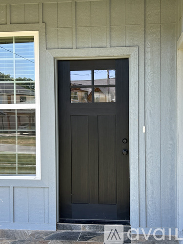 A black door is set in a white frame.
