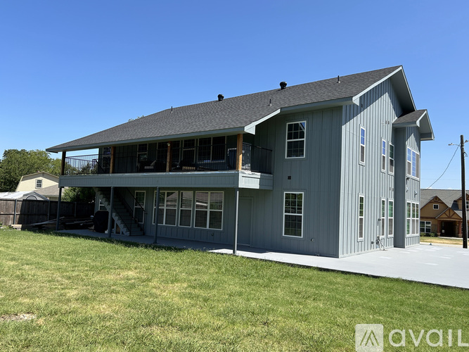 A large grey house with a porch and a covered patio.