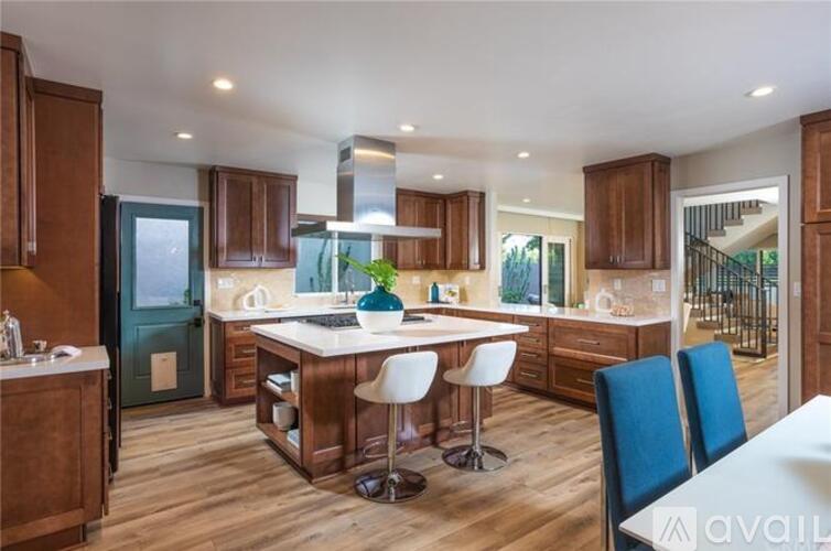 A modern kitchen with wooden cabinets and a central island.