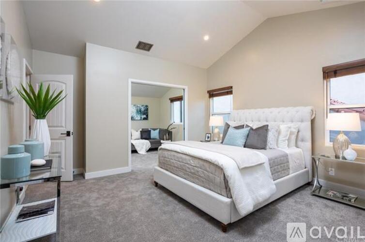 A bedroom with a large bed and a nightstand with a lamp.